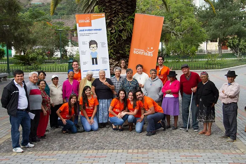 Voluntarios de Vistiendo Sonrisas entregando ropa en una jornada de donación
